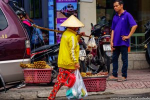 Eine schwer tragende Frau im Herzen von Saigon, um ihren Food-Stand aufzubauen.