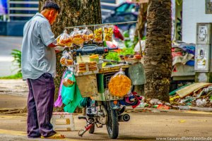 Mann verkauft Essen vom Roller aus in Saigon