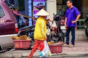 Frau trägt ihr Essen zum Straßenstand in Saigon