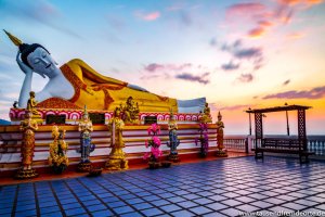 Liegende Buddhastatue mit Sonnenaufgang im Hintergrund